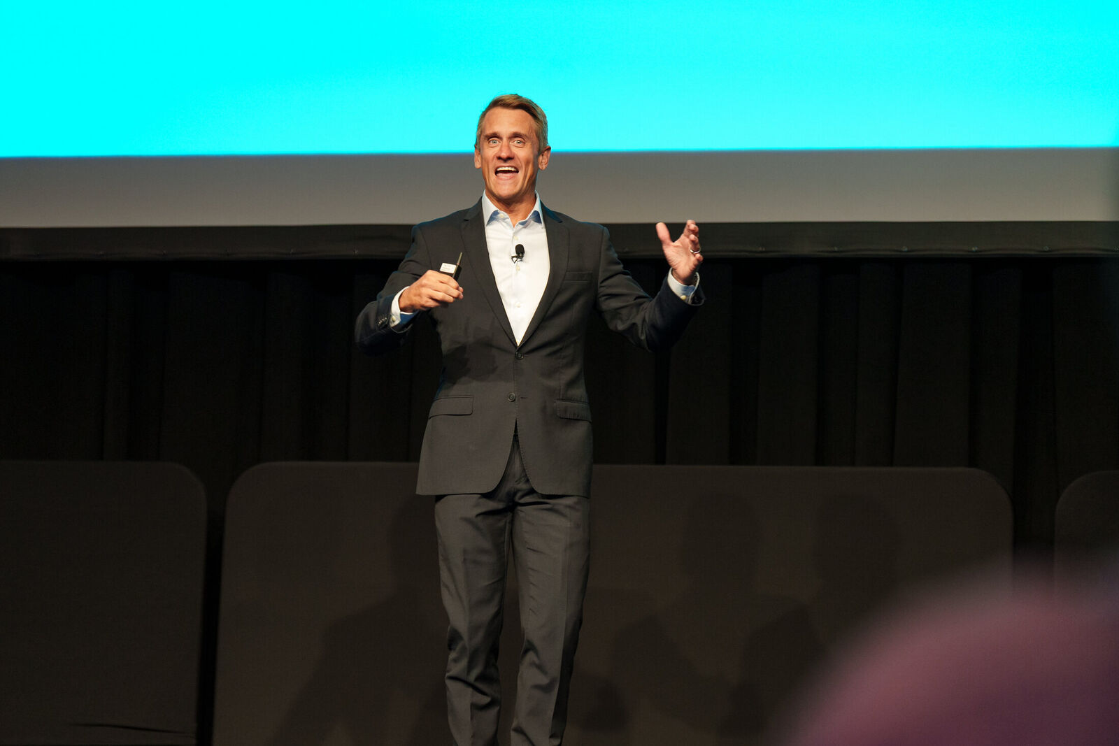 Adam Franklin speaking on stage at a conference